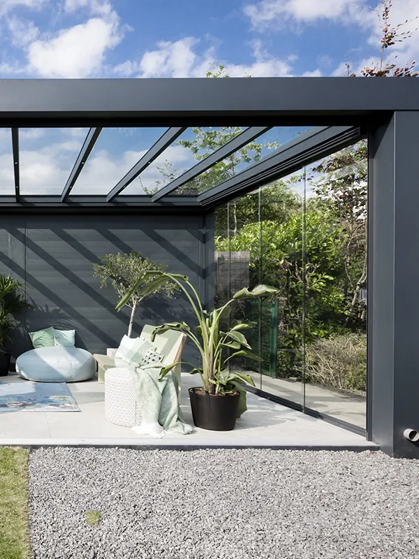 Dunkles, kubisches Designerdach über einer Terrasse mit Pflanzen